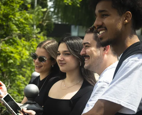 Four players laughing in the sun with the tablet