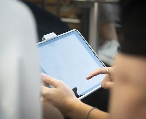 Spielerin liest die Aufgabe auf dem Tablet