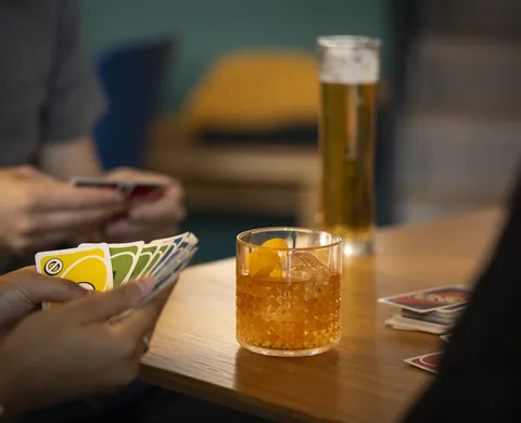Kartenspiel und Cocktail auf dem Bartisch