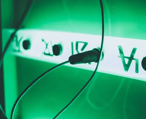 Kabel vor grün leuchtenden Alien-Schriftzeichen
