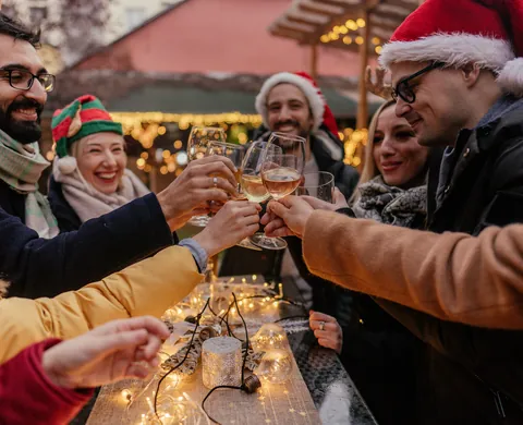 Freunde stossen mit Glühwein auf dem Weihnachtsmarkt an