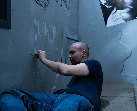 Player searching for clues on a prison cell wall
