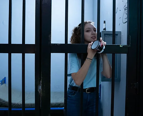 Player behind bars holding handcuffs
