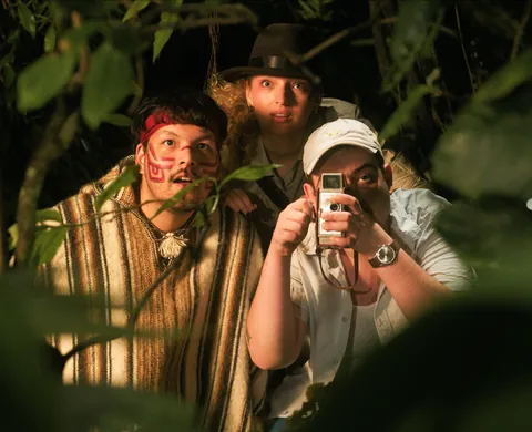 Three adventurers peering through the jungle thicket