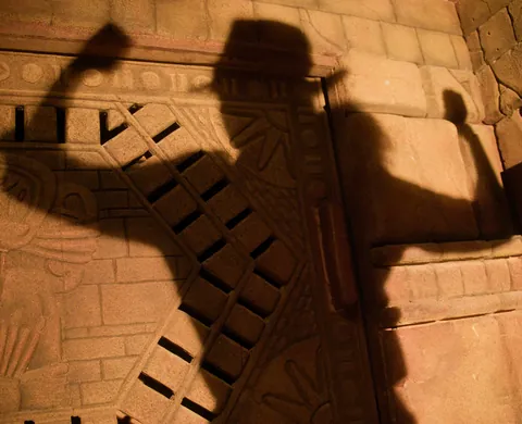 Shadows of adventurers on the temple wall reliefs