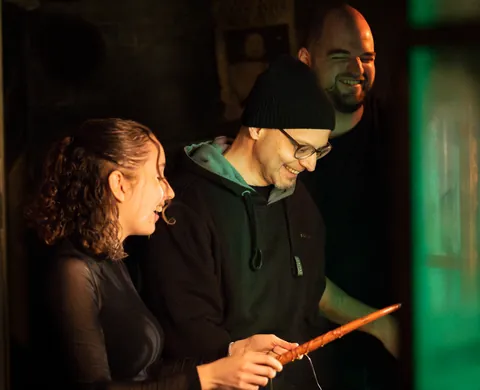 Three players with a wand solving a puzzle