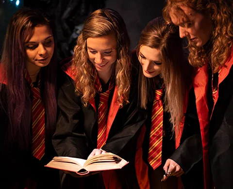 World of Magic Escape Room Team liest in einem Zauberbuch